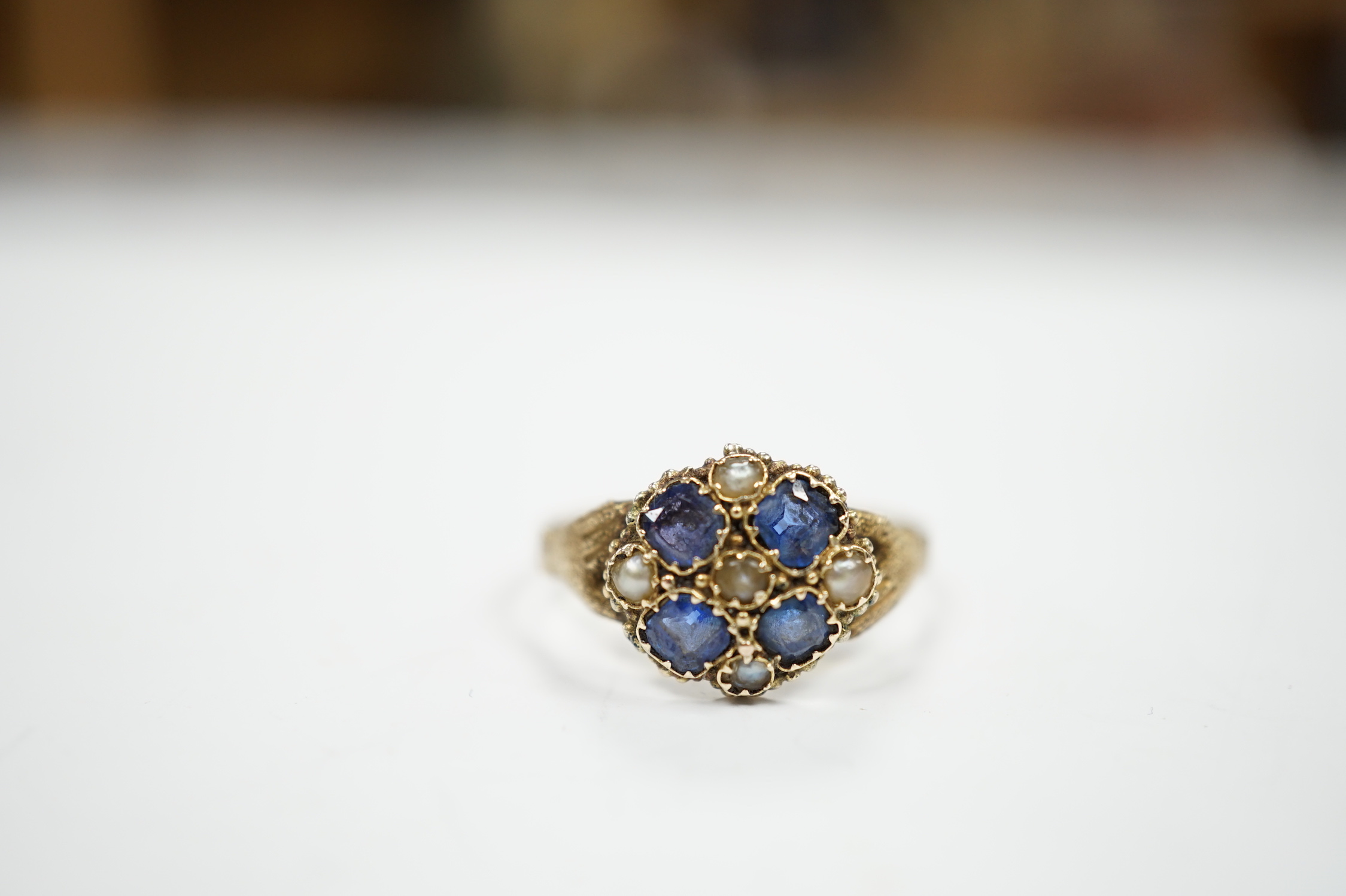 A Victorian 12ct gold sapphire and seed pearl cluster set ring, size M, gross weight 1.6 grams.